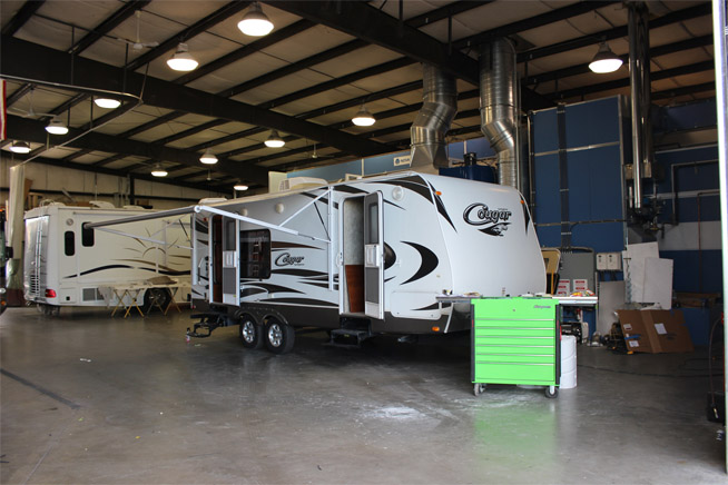 A white RV Cougar in the maintenance shop.